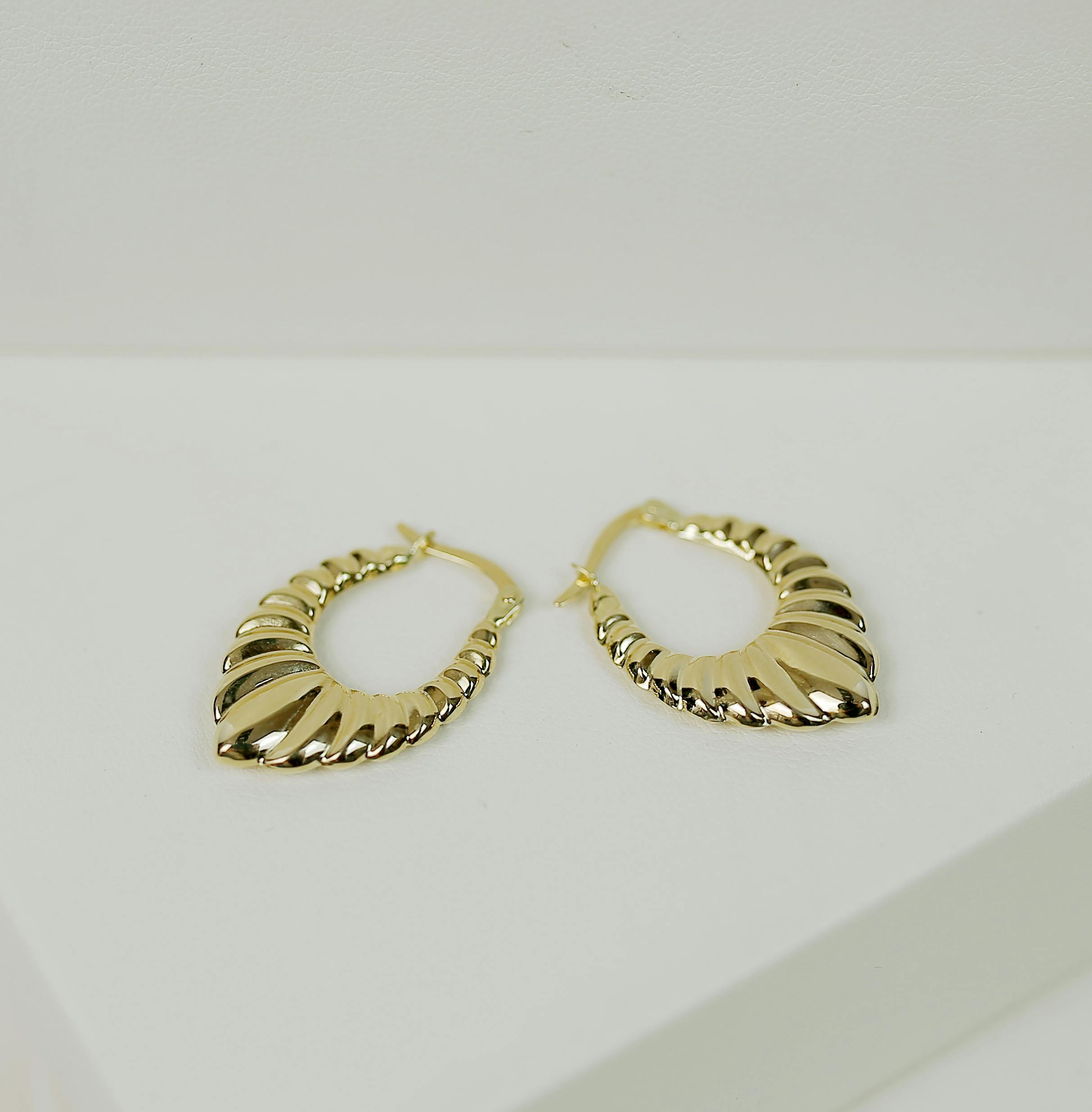 Showcasing stylish gold earrings on a minimalist display perfect for fashion collections.